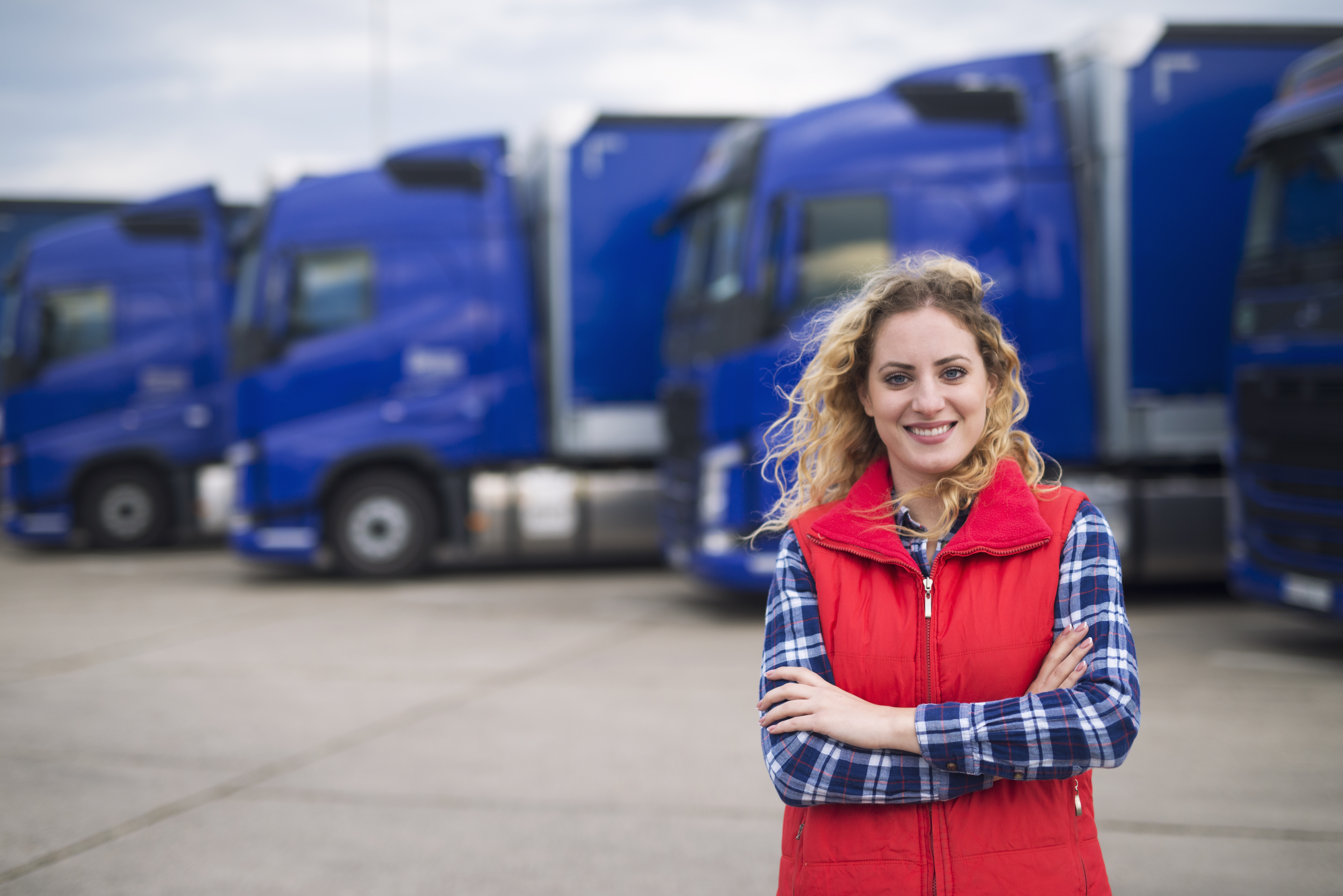 AT6ix fleet driver standing in front of logistics trucks